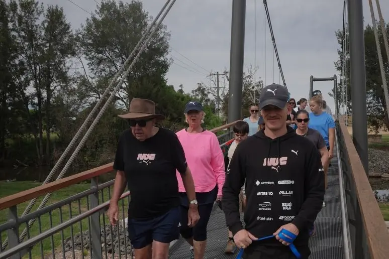 <p>JP and Nedd Brockmann lead the walk across the Swinging Bridge. PHOTO: Bursty</p>\\n