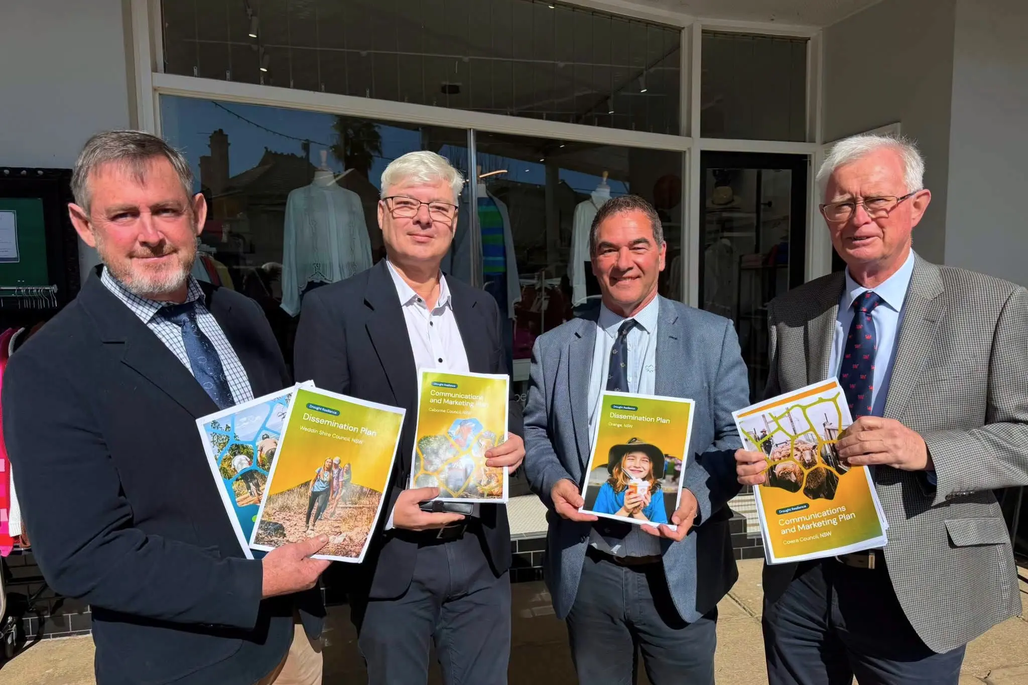 <p>Weddin Shire mayor Paul Best, Cabonne councillor Andrew Rawson, Orange City mayor Tony Mileto and Cowra Shire mayor Paul Smith with the Regional Drought Resilience Plan outside Scope Clothing. </p>\\n