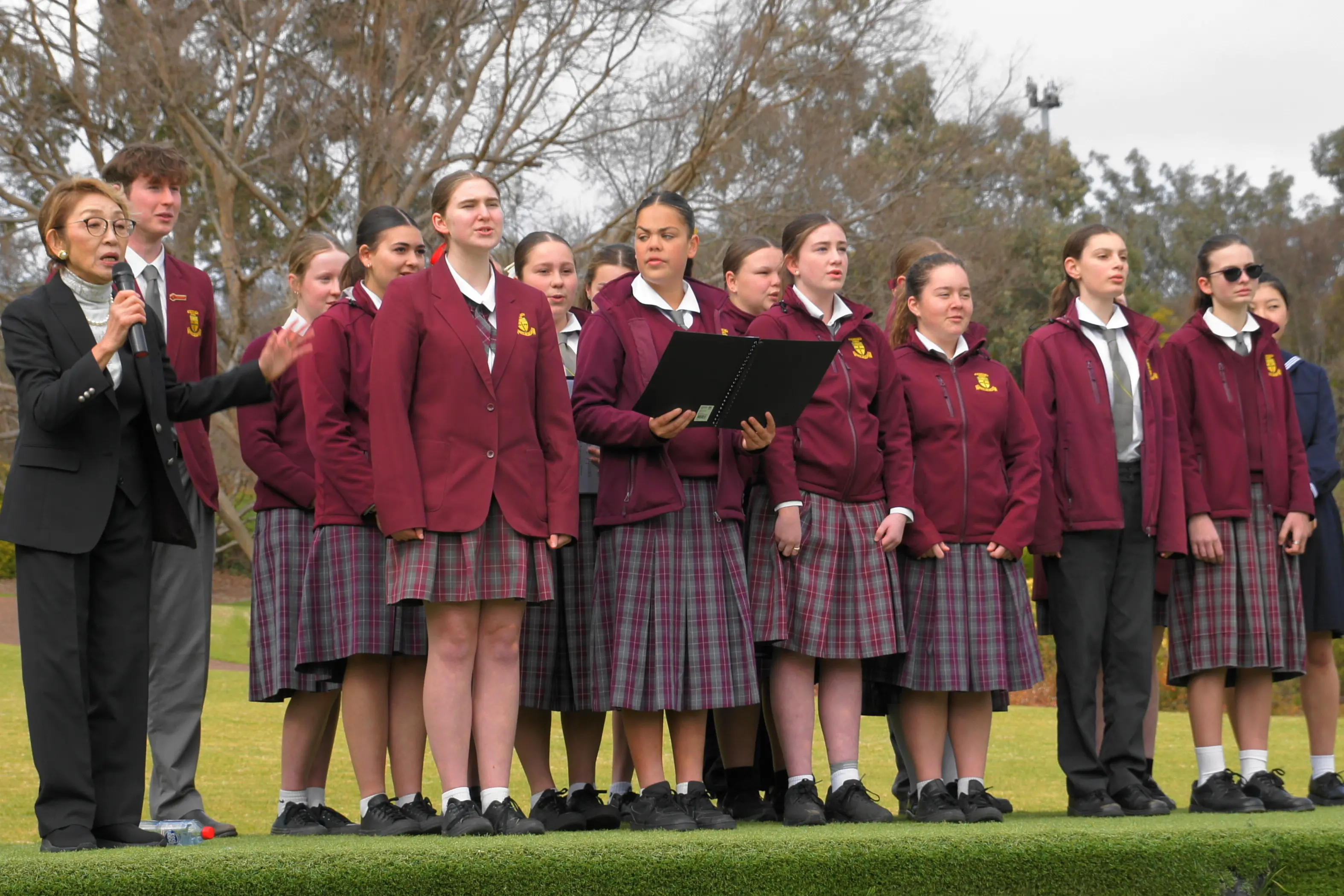 <p>Atsuko Aria with members of the St Raphael\\u2019s Catholic School Choir, accompanied by music teacher Lisa Flanagan. PHOTO: Robyn Ryan </p>\\n